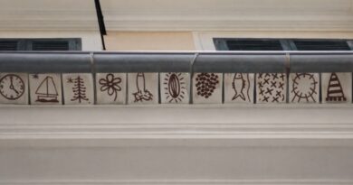 El tejat pintat de Lluís Fuster recupera una antiga tradició de l’arquitectura mallorquina Fa 25 anys l’artista va rescatar la decoració de teules pintades als alerons, una pràctica habitual durant segles a Mallorca. Palma, març de 2026. Es compleixen 25 anys des que l’artista mallorquí Lluís Fuster va recuperar una antiga tradició de l’arquitectura popular de l’illa: la decoració de les teules dels alerons amb motius pintats a mà. Una pràctica que durant segles va formar part del paisatge constructiu mallorquí i que encara es pot observar en alguns edificis del vall de Sóller, on se’n conserven diversos exemples. Fuster va decidir rescatar aquesta tradició i traslladar-la a Palma, concretament al seu estudi situat al carrer Set Cantons, número 6, on també es troba l’espai El Mirador. “Des que les vaig veure sempre vaig voler pintar alguna cosa així”, recorda l’artista. L’oportunitat va arribar amb la reforma de la façana de l’edifici. “Ho vaig proposar als propietaris i van estar d’acord a fer la intervenció”, explica. Una tradició amb segles d’història La tradició de pintar teules es remunta, com a mínim, al segle XVI. La peça més antiga documentada està datada l’any 1525, mentre que les darreres registrades corresponen a 1889. Els motius decoratius solien ser senzills i estaven vinculats sobretot a elements naturals, com el sol, la lluna, animals, plantes o formes geomètriques. El color més utilitzat era el roig almagra, aplicat directament sobre la teula o al fresc damunt una capa de cal. Una curiositat d’aquesta tradició és que la mesura del dibuix sovint corresponia al palmell de la mà del mestre d’obres, fet que donava a cada peça un caràcter personal i artesanal. Una reinterpretació contemporània Lluís Fuster no és l’únic artista contemporani que s’ha interessat per aquesta pràctica decorativa, que alguns estudis relacionen amb possibles influències musulmanes presents a l’illa. També l’han reinterpretada creadors com Luis Castaldo, Jaume Piña, Paco Lorente o José María Sicilia. Amb aquesta intervenció, Fuster no només va recuperar una tècnica decorativa en desús, sinó que va contribuir a reactivar una part del patrimoni visual mallorquí, integrant-lo dins el paisatge urbà contemporani i retornant visibilitat a una tradició gairebé oblidada. 🏛️ FITXA SORTIM 📍 Lloc: Estudi de Lluís Fuster – Espai El Mirador 📌 Adreça: Carrer Set Cantons, 6 📍 Municipi: Palma · Mallorca 🎨 Intervenció artística: Teules pintades als alerons 👨‍🎨 Artista: Lluís Fuster 📅 Any de la intervenció: 2001 (fa 25 anys) 🧭 Context: Recuperació d’una tradició decorativa de l’arquitectura popular mallorquina present sobretot al vall de Sóller.