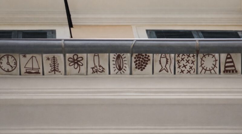 El tejat pintat de Lluís Fuster recupera una antiga tradició de l’arquitectura mallorquina Fa 25 anys l’artista va rescatar la decoració de teules pintades als alerons, una pràctica habitual durant segles a Mallorca. Palma, març de 2026. Es compleixen 25 anys des que l’artista mallorquí Lluís Fuster va recuperar una antiga tradició de l’arquitectura popular de l’illa: la decoració de les teules dels alerons amb motius pintats a mà. Una pràctica que durant segles va formar part del paisatge constructiu mallorquí i que encara es pot observar en alguns edificis del vall de Sóller, on se’n conserven diversos exemples. Fuster va decidir rescatar aquesta tradició i traslladar-la a Palma, concretament al seu estudi situat al carrer Set Cantons, número 6, on també es troba l’espai El Mirador. “Des que les vaig veure sempre vaig voler pintar alguna cosa així”, recorda l’artista. L’oportunitat va arribar amb la reforma de la façana de l’edifici. “Ho vaig proposar als propietaris i van estar d’acord a fer la intervenció”, explica. Una tradició amb segles d’història La tradició de pintar teules es remunta, com a mínim, al segle XVI. La peça més antiga documentada està datada l’any 1525, mentre que les darreres registrades corresponen a 1889. Els motius decoratius solien ser senzills i estaven vinculats sobretot a elements naturals, com el sol, la lluna, animals, plantes o formes geomètriques. El color més utilitzat era el roig almagra, aplicat directament sobre la teula o al fresc damunt una capa de cal. Una curiositat d’aquesta tradició és que la mesura del dibuix sovint corresponia al palmell de la mà del mestre d’obres, fet que donava a cada peça un caràcter personal i artesanal. Una reinterpretació contemporània Lluís Fuster no és l’únic artista contemporani que s’ha interessat per aquesta pràctica decorativa, que alguns estudis relacionen amb possibles influències musulmanes presents a l’illa. També l’han reinterpretada creadors com Luis Castaldo, Jaume Piña, Paco Lorente o José María Sicilia. Amb aquesta intervenció, Fuster no només va recuperar una tècnica decorativa en desús, sinó que va contribuir a reactivar una part del patrimoni visual mallorquí, integrant-lo dins el paisatge urbà contemporani i retornant visibilitat a una tradició gairebé oblidada. 🏛️ FITXA SORTIM 📍 Lloc: Estudi de Lluís Fuster – Espai El Mirador 📌 Adreça: Carrer Set Cantons, 6 📍 Municipi: Palma · Mallorca 🎨 Intervenció artística: Teules pintades als alerons 👨‍🎨 Artista: Lluís Fuster 📅 Any de la intervenció: 2001 (fa 25 anys) 🧭 Context: Recuperació d’una tradició decorativa de l’arquitectura popular mallorquina present sobretot al vall de Sóller.